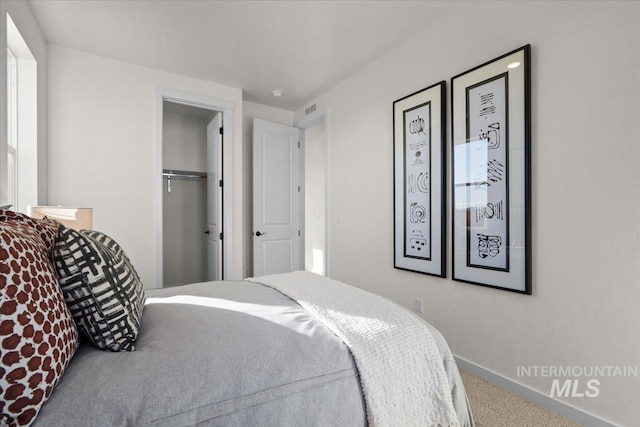 bedroom featuring a closet, carpet flooring, baseboards, and visible vents