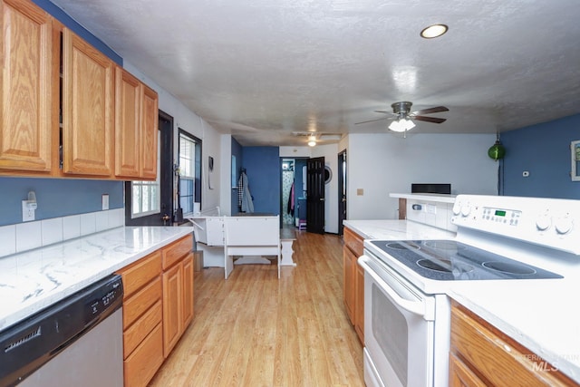 731 W 4th St, Emmett, ID 83617 - kitchen featuring white electric range, dishwasher, light wood-style flooring, a ceiling fan, and light stone counters