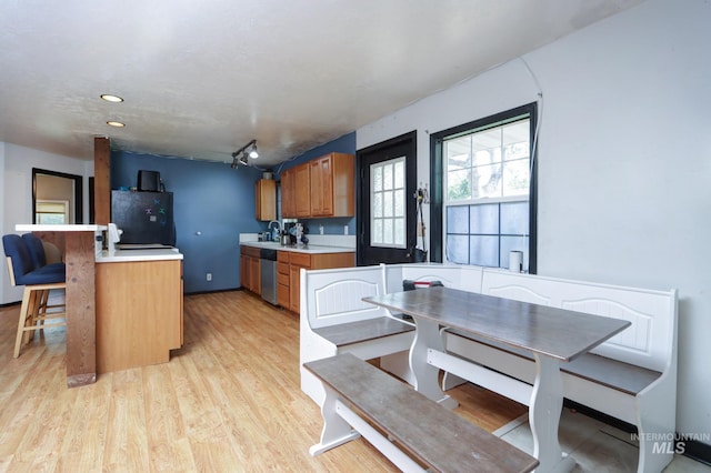 731 W 4th St, Emmett, ID 83617 - kitchen with refrigerator, dishwasher, light wood-style floors, light countertops, and a kitchen breakfast bar