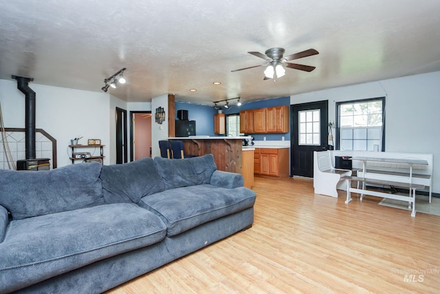 731 W 4th St, Emmett, ID 83617 - living room with a wood stove, rail lighting, ceiling fan, and light wood finished floors