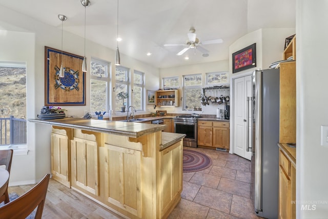 kitchen with a kitchen bar, kitchen peninsula, stainless steel appliances, decorative light fixtures, and sink