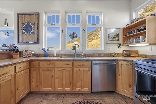 kitchen featuring sink, hanging light fixtures, appliances with stainless steel finishes, and tile countertops