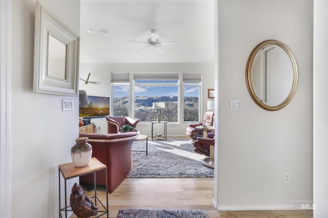 living room with ceiling fan and light hardwood / wood-style flooring