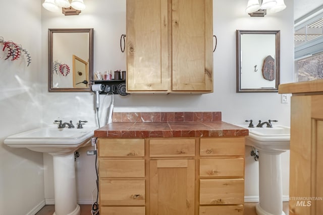 kitchen featuring tile counters, sink, and light brown cabinets