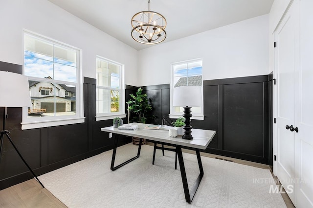 home office featuring a chandelier and light hardwood / wood-style floors