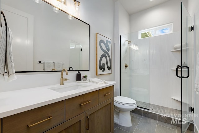 bathroom featuring a shower with door, toilet, and vanity