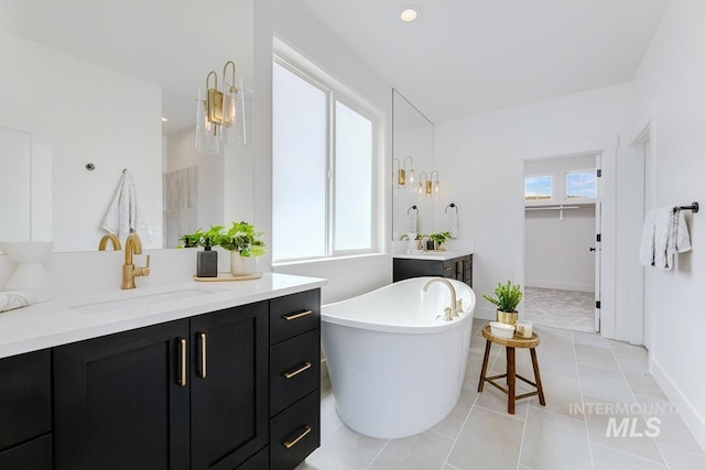 bathroom featuring vanity, a tub, plenty of natural light, and tile patterned floors