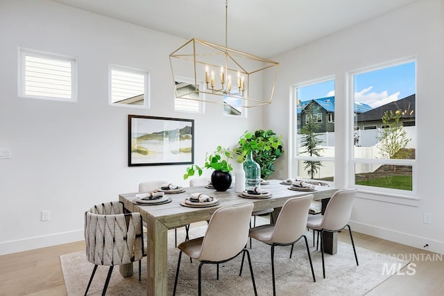 dining area featuring light wood-type flooring and a chandelier