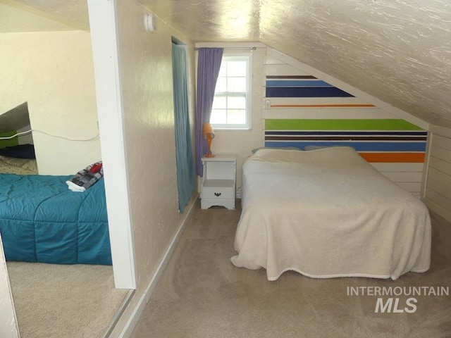 carpeted bedroom with lofted ceiling and a textured ceiling