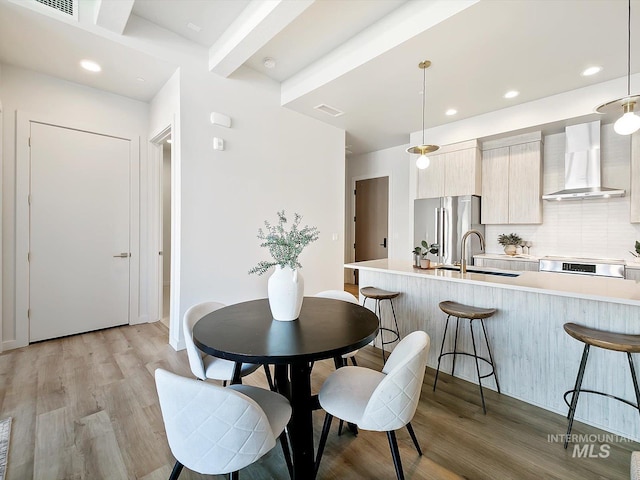 dining area with light wood-type flooring and sink