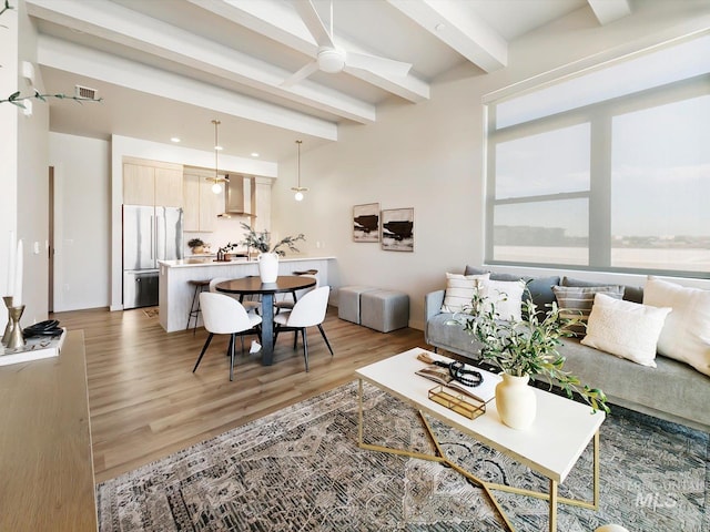 living room featuring beam ceiling and hardwood / wood-style floors