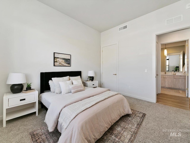 carpeted bedroom featuring ensuite bathroom