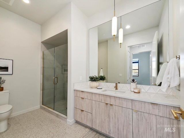 bathroom with an enclosed shower, vanity, and toilet