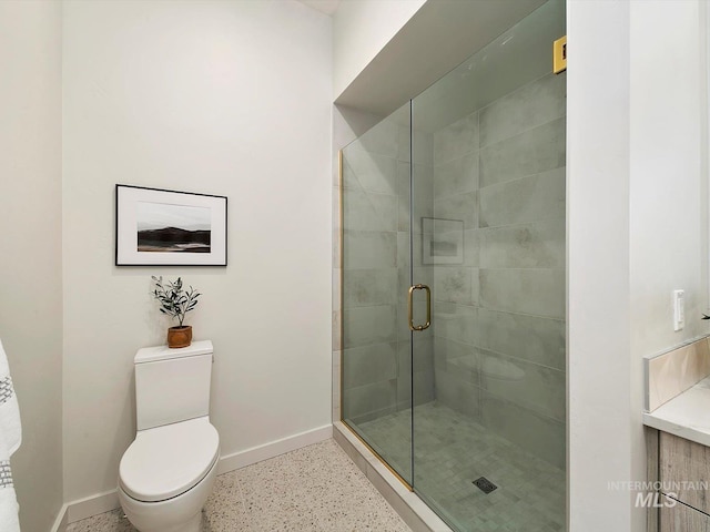 bathroom with a shower with shower door and toilet