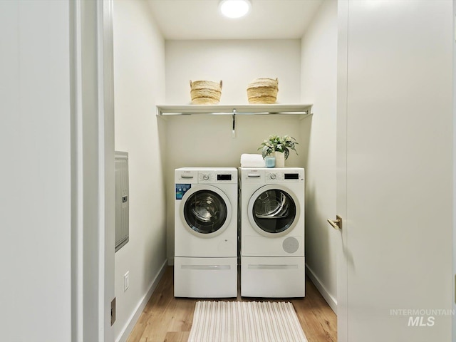 laundry room featuring light wood-type flooring and separate washer and dryer