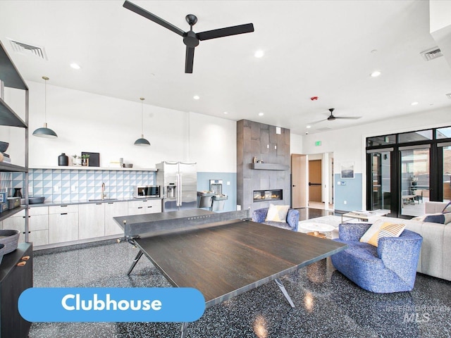 kitchen featuring white cabinetry, sink, hanging light fixtures, and stainless steel appliances