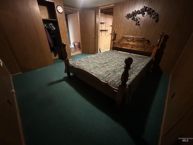 bedroom featuring carpet flooring, wooden walls, and a closet