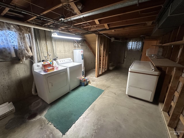 basement featuring refrigerator, washer and clothes dryer, and water heater