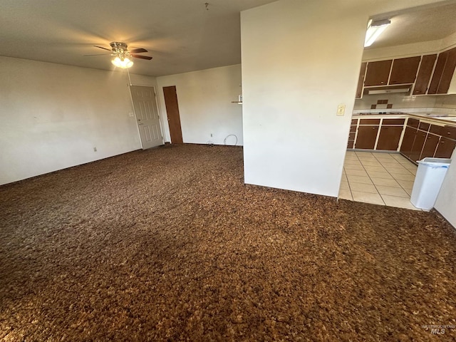 tiled empty room featuring ceiling fan and sink