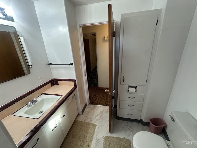 bathroom with vanity, toilet, and backsplash