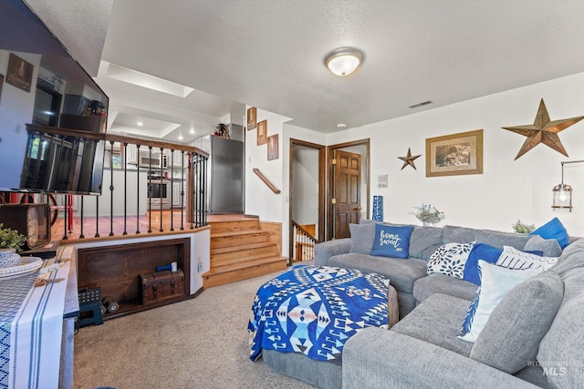 carpeted living area with visible vents, a textured ceiling, and stairs