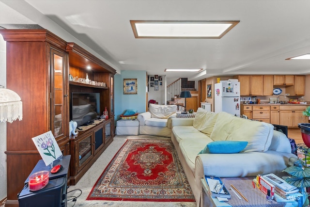 living area with stairway and light carpet
