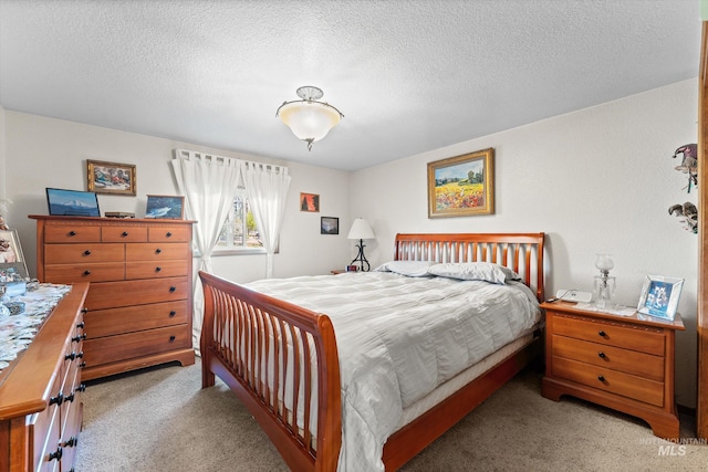 bedroom featuring carpet flooring and a textured ceiling