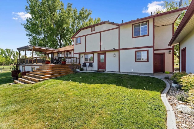 back of property featuring a yard, a wooden deck, and stucco siding