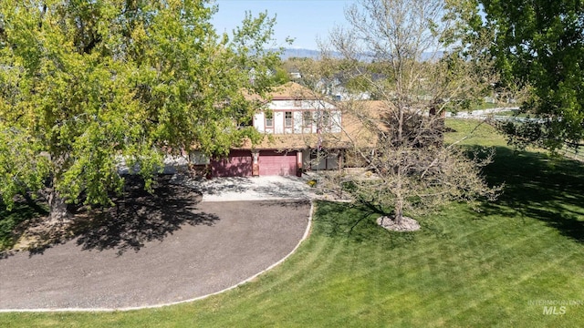 view of front of house with an attached garage, a front lawn, and aphalt driveway