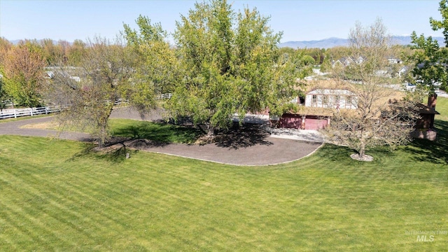 view of yard featuring fence and a mountain view