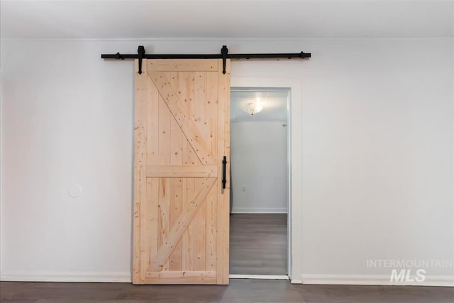 216 9th Ave N, Nampa, ID 83687 - empty room with a barn door, dark wood finished floors, and baseboards