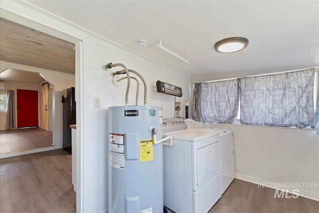216 9th Ave N, Nampa, ID 83687 - laundry area featuring water heater, washing machine and dryer, wood finished floors, and baseboards