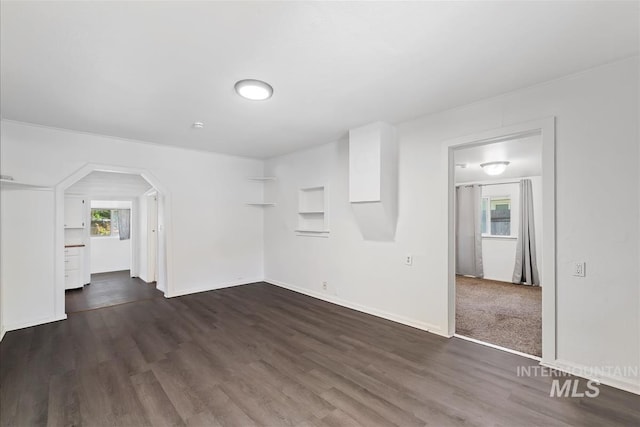 216 9th Ave N, Nampa, ID 83687 - unfurnished living room featuring dark wood-style flooring, arched walkways, and baseboards
