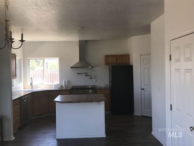 kitchen with a textured ceiling, wall chimney range hood, black appliances, dark hardwood / wood-style floors, and a kitchen island