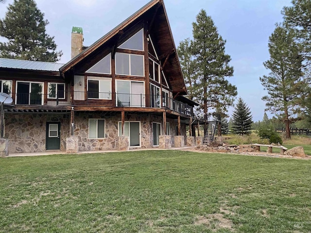 back of house featuring a deck and a lawn