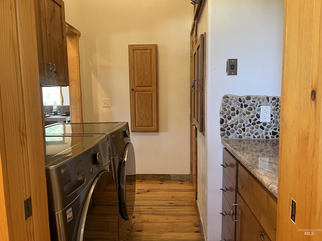 laundry room featuring cabinets, separate washer and dryer, and light hardwood / wood-style floors