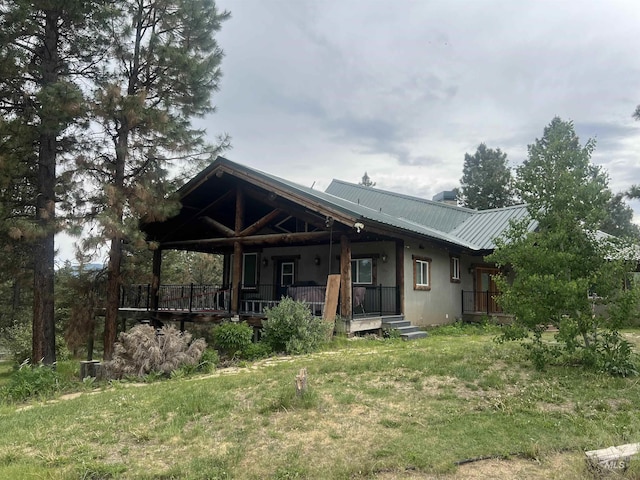 back of property featuring a porch and a lawn