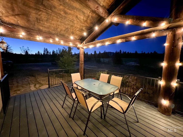 deck at twilight featuring a water view