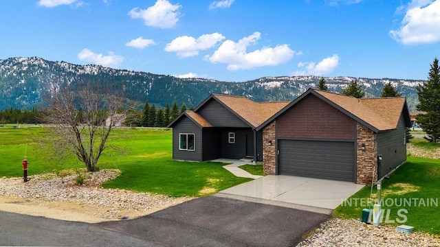 view of front of house with a mountain view, a garage, a front lawn, and driveway
