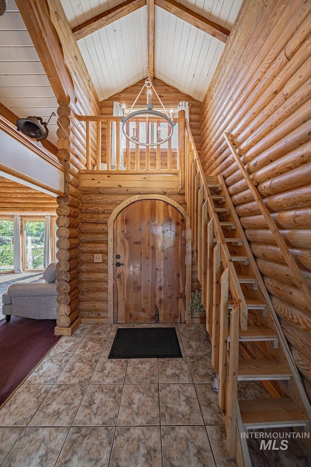 tiled foyer with high vaulted ceiling, wooden ceiling, beam ceiling, and a notable chandelier