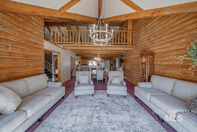 living room with stairway, beamed ceiling, an inviting chandelier, log walls, and high vaulted ceiling