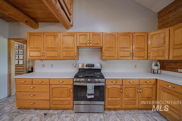 kitchen with light tile patterned floors, wooden ceiling, vaulted ceiling with beams, stainless steel gas range, and light countertops