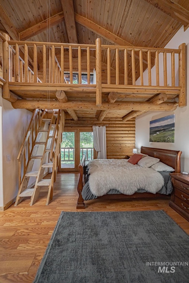 unfurnished bedroom featuring log walls, wood finished floors, high vaulted ceiling, wooden ceiling, and beamed ceiling