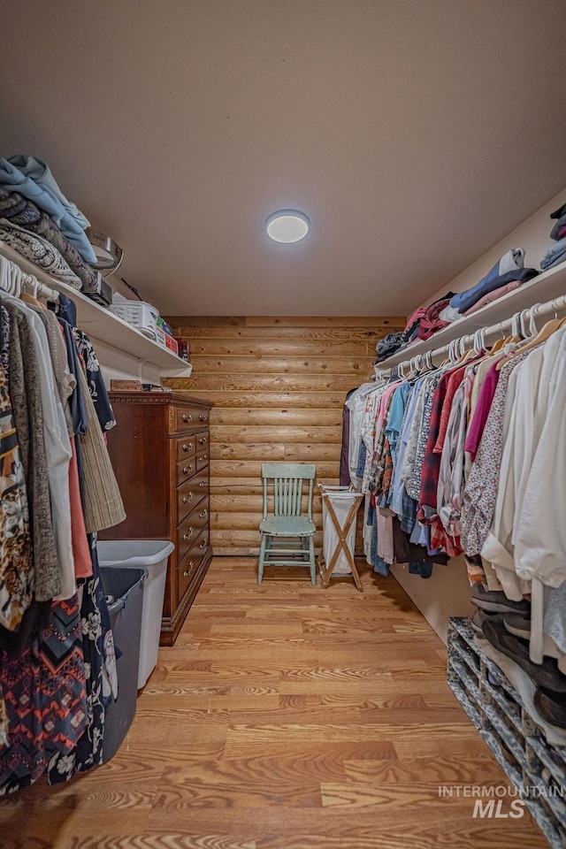 walk in closet with light wood-style flooring