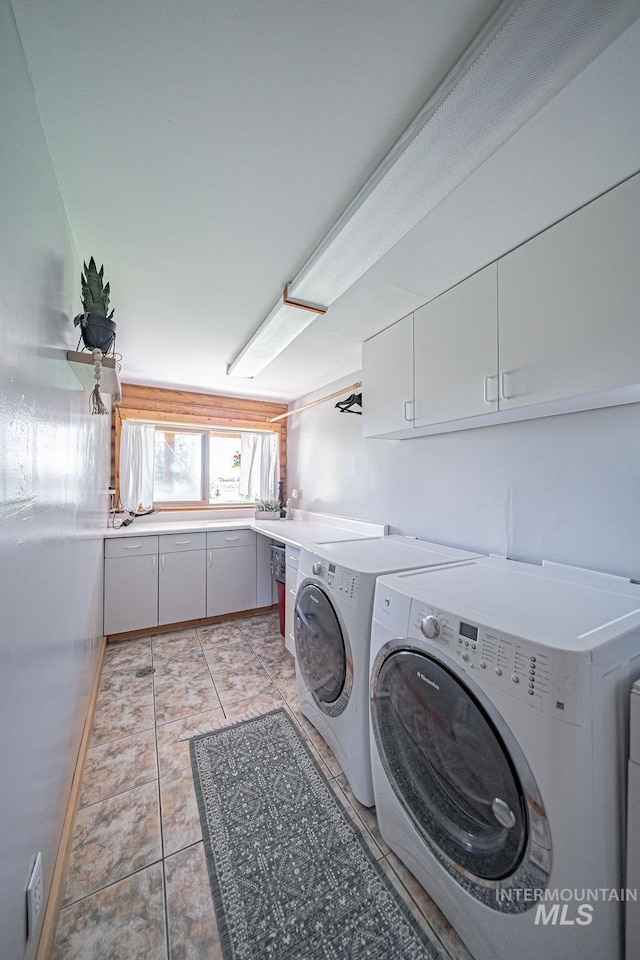 washroom featuring washer and clothes dryer, light tile patterned flooring, and cabinet space