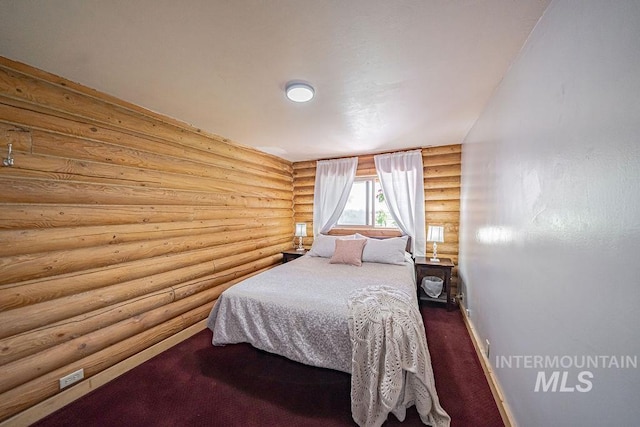 bedroom with baseboards, dark carpet, and log walls