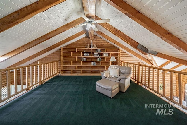 unfurnished room featuring lofted ceiling with beams, ceiling fan, rustic walls, and carpet