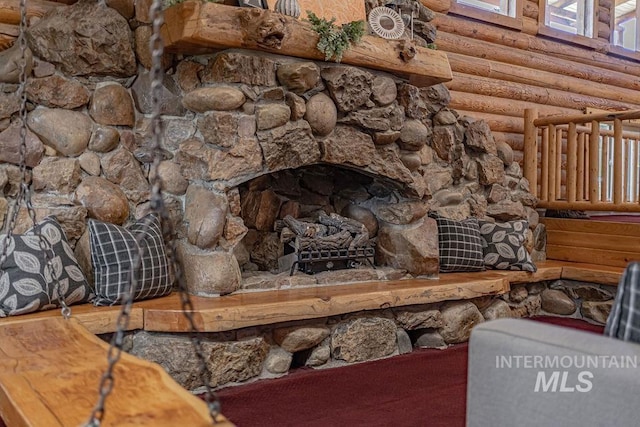 room details with a fireplace with raised hearth and log walls