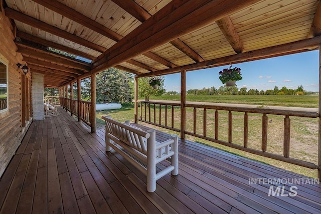 deck featuring a rural view and a lawn