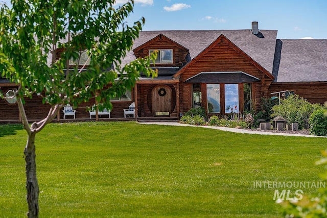 view of front of house featuring a chimney, a front lawn, and roof with shingles